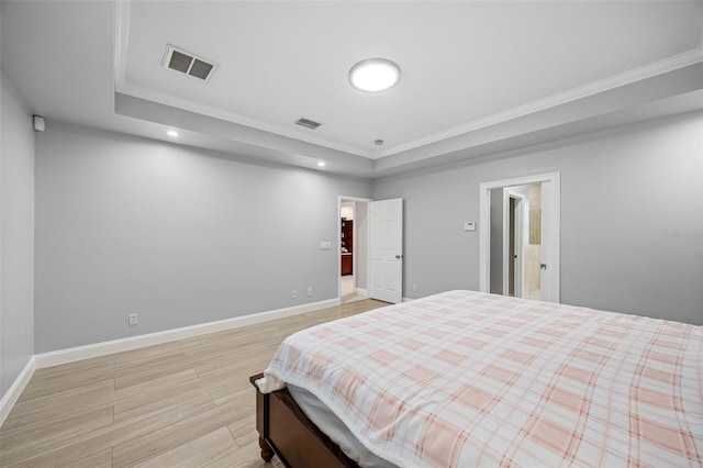 bedroom featuring a tray ceiling, light wood-style floors, baseboards, crown molding, and recessed lighting