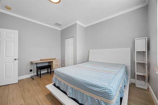 bedroom with crown molding, light wood-style flooring, baseboards, and a closet