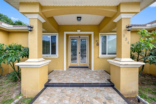 property entrance featuring french doors and stucco siding