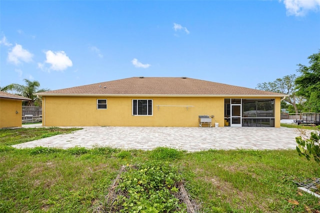 back of property featuring a patio area, a sunroom, and stucco siding