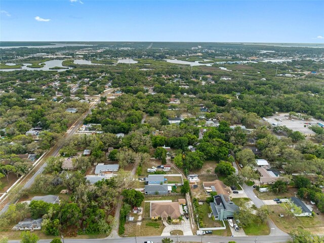aerial view of property and surrounding area featuring a large body of water and nearby suburban area