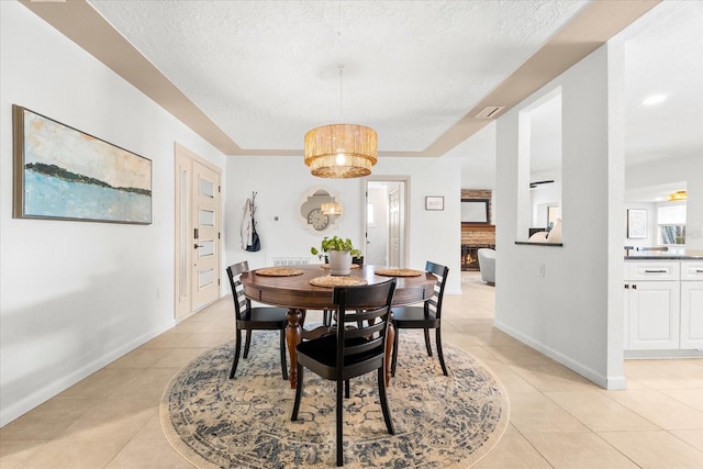 8848 Sunlit Cove Dr NE, Saint Petersburg, FL 33702 - dining space featuring light tile patterned floors, a textured ceiling, and baseboards