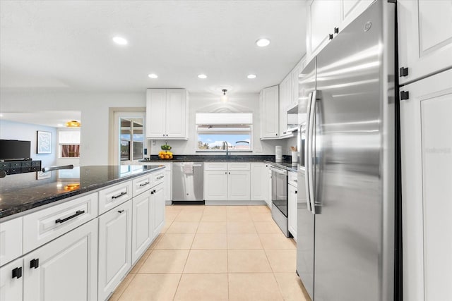 8848 Sunlit Cove Dr NE, Saint Petersburg, FL 33702 - kitchen featuring stainless steel appliances, white cabinets, recessed lighting, light tile patterned flooring, and dark stone counters
