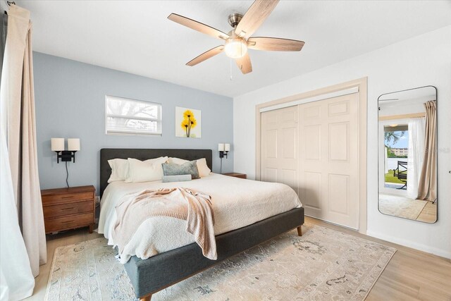 8848 Sunlit Cove Dr NE, Saint Petersburg, FL 33702 - bedroom with light wood-style flooring, a closet, a ceiling fan, and baseboards