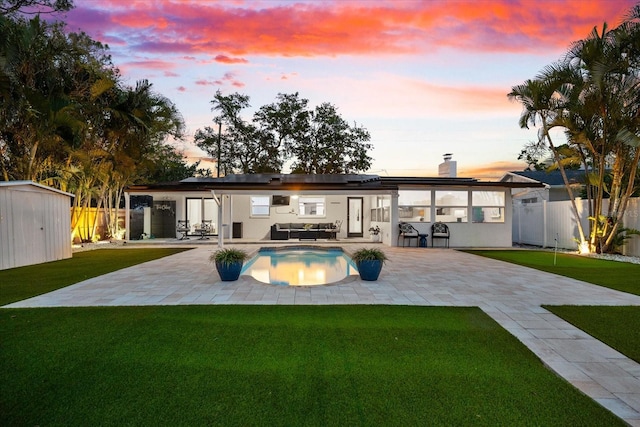 8848 Sunlit Cove Dr NE, Saint Petersburg, FL 33702 - rear view of property featuring solar panels, a patio, a chimney, an outdoor hangout area, and stucco siding