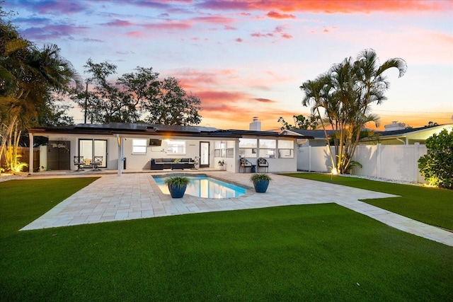 8848 Sunlit Cove Dr NE, Saint Petersburg, FL 33702 - back of house with roof mounted solar panels, a patio, and an outdoor hangout area