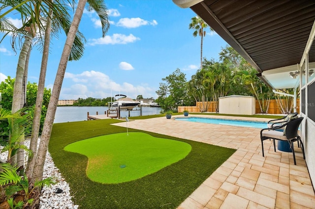 8848 Sunlit Cove Dr NE, Saint Petersburg, FL 33702 - view of swimming pool featuring a patio area, an area to practice putting, boat lift, a boat dock, and a water view