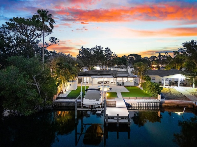 8848 Sunlit Cove Dr NE, Saint Petersburg, FL 33702 - dock area with boat lift, a water view, a patio area, and a yard