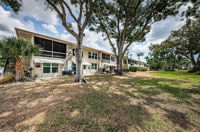 5694 40th Ter N Unit 423, Kenneth City, FL 33709 - rear view of property featuring central air condition unit, a yard, and stucco siding