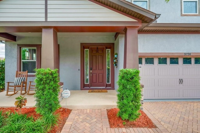 doorway to property featuring stucco siding and a porch
