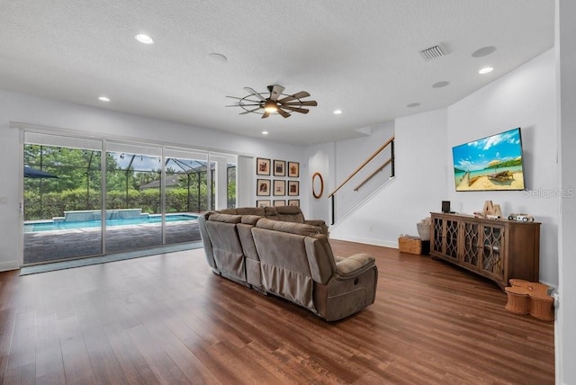 living room with a ceiling fan, wood finished floors, recessed lighting, baseboards, and a textured ceiling
