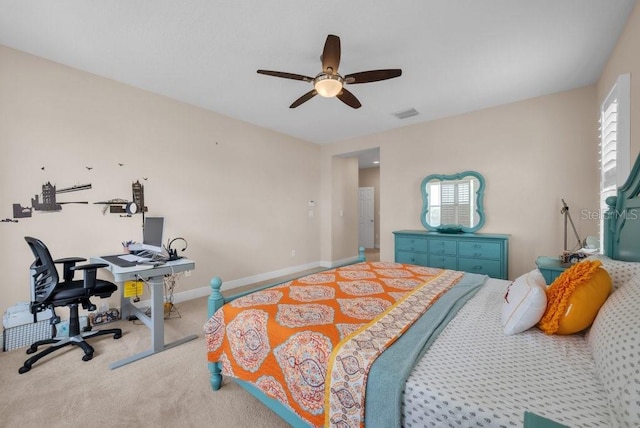 carpeted bedroom featuring an office area, a ceiling fan, and baseboards