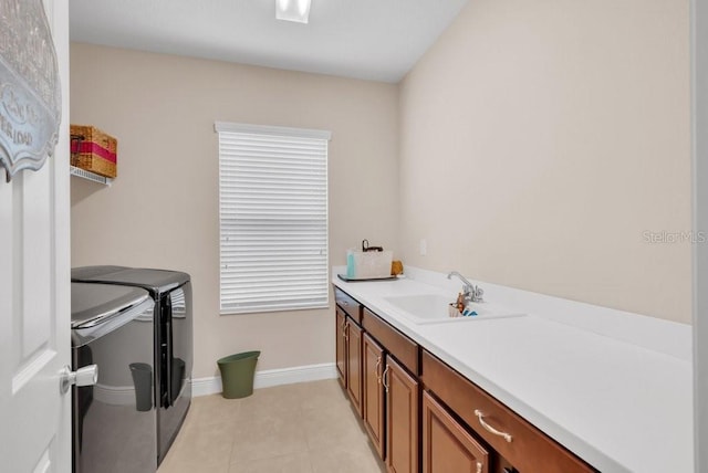clothes washing area featuring washer and dryer, cabinet space, light tile patterned floors, and baseboards