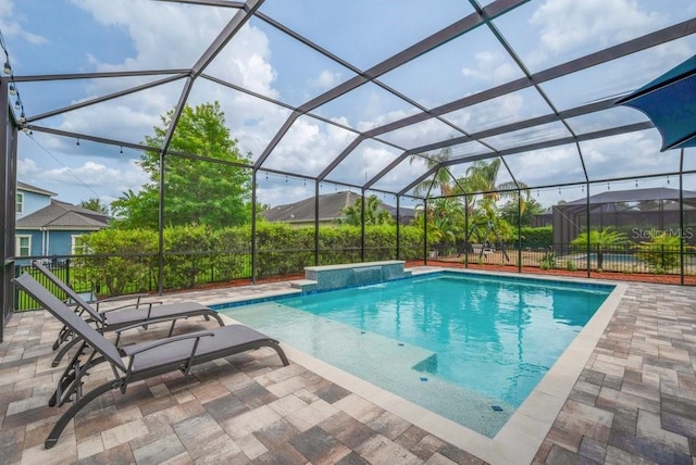 view of pool with a patio area and glass enclosure