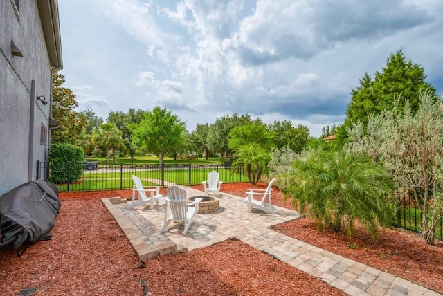 view of patio featuring an outdoor fire pit and fence