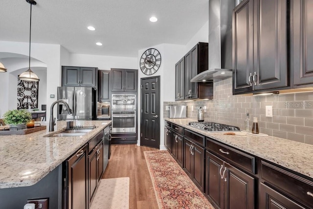 5724 Shell Ridge Dr, Lithia, FL 33547 - kitchen with stainless steel appliances, wall chimney range hood, decorative backsplash, light stone counters, and recessed lighting
