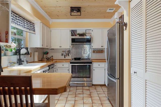 854 77th Ave N, Saint Petersburg, FL 33702 - kitchen with stainless steel appliances, a sink, decorative backsplash, light countertops, and white cabinetry