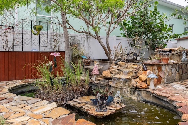 854 77th Ave N, Saint Petersburg, FL 33702 - view of patio featuring fence and a garden pond