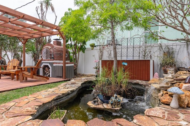 854 77th Ave N, Saint Petersburg, FL 33702 - view of yard with a garden pond, a deck, fence, and a pergola