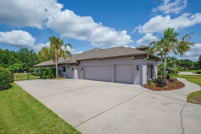 5507 Keeler Oak St, Lithia, FL 33547 - view of side of property with stucco siding, an attached garage, driveway, and a lawn
