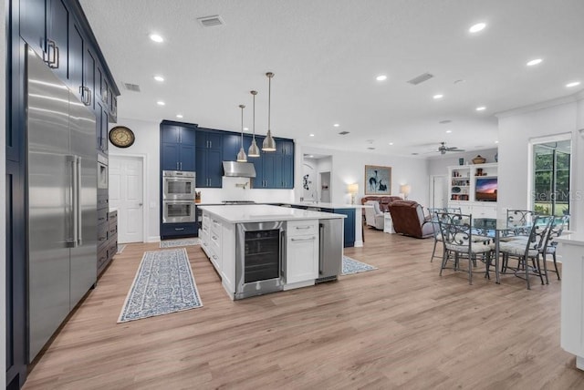 5507 Keeler Oak St, Lithia, FL 33547 - kitchen featuring wine cooler, stainless steel appliances, wall chimney range hood, light countertops, and open floor plan
