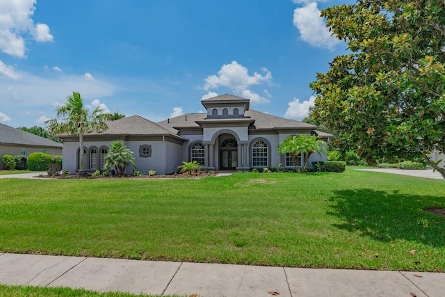 5507 Keeler Oak St, Lithia, FL 33547 - mediterranean / spanish home with french doors, a front yard, stucco siding, and a shingled roof