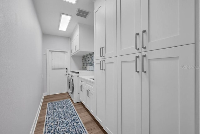 5507 Keeler Oak St, Lithia, FL 33547 - laundry room featuring cabinet space, washer / dryer, and wood finished floors