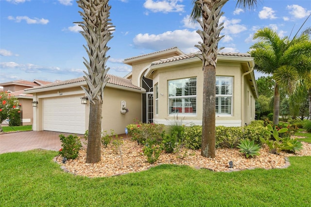 16101 Cape Coral Dr, Wimauma, FL 33598 - mediterranean / spanish-style home featuring a garage, decorative driveway, stucco siding, and a front lawn