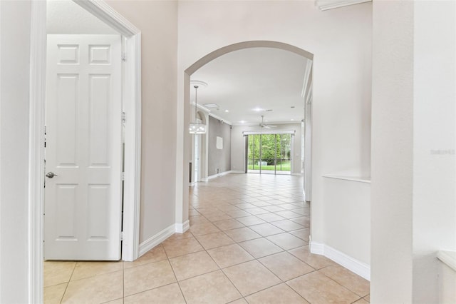 16101 Cape Coral Dr, Wimauma, FL 33598 - hall featuring arched walkways, light tile patterned floors, baseboards, and ornamental molding