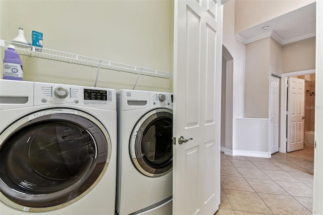 16101 Cape Coral Dr, Wimauma, FL 33598 - laundry area with washer and clothes dryer, light tile patterned floors, crown molding, baseboards, and arched walkways