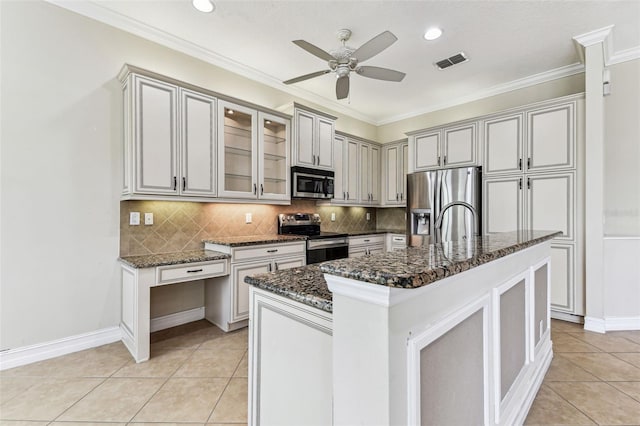 16101 Cape Coral Dr, Wimauma, FL 33598 - kitchen with stainless steel appliances, ceiling fan, dark stone countertops, backsplash, and light tile patterned floors