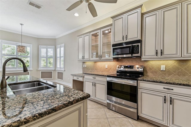 16101 Cape Coral Dr, Wimauma, FL 33598 - kitchen featuring stainless steel appliances, a sink, decorative backsplash, a ceiling fan, and glass insert cabinets
