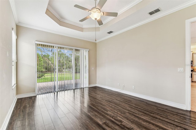 16101 Cape Coral Dr, Wimauma, FL 33598 - spare room featuring dark wood-style floors, a ceiling fan, a tray ceiling, ornamental molding, and baseboards