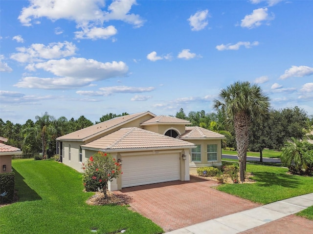 16101 Cape Coral Dr, Wimauma, FL 33598 - mediterranean / spanish home featuring stucco siding, decorative driveway, an attached garage, and a front yard