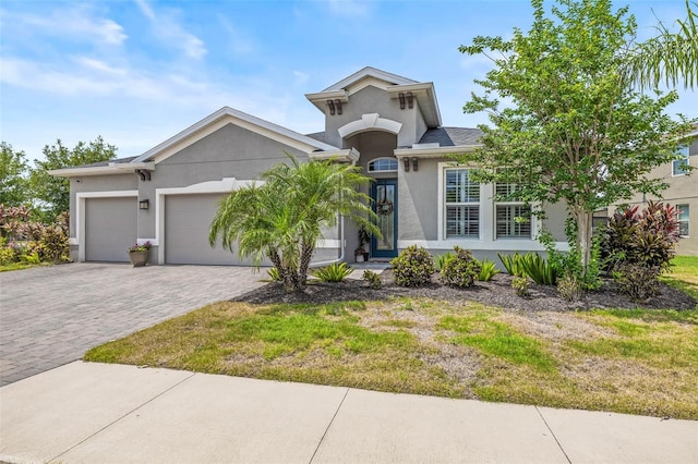 11322 Lake Lucaya Dr, Riverview, FL 33579 - view of front of home featuring stucco siding, a garage, decorative driveway, and a front yard