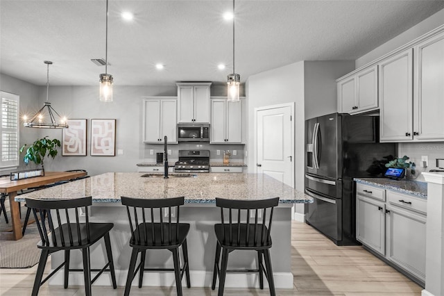 11322 Lake Lucaya Dr, Riverview, FL 33579 - kitchen featuring appliances with stainless steel finishes, recessed lighting, light stone counters, a center island with sink, and a sink