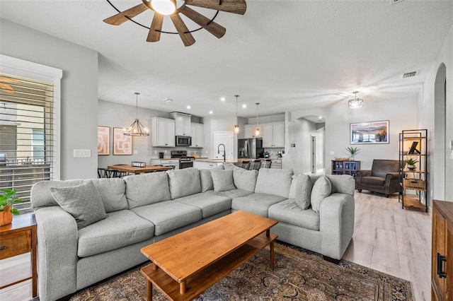 11322 Lake Lucaya Dr, Riverview, FL 33579 - living area featuring arched walkways, ceiling fan, light wood-type flooring, and recessed lighting