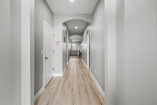 11322 Lake Lucaya Dr, Riverview, FL 33579 - hall featuring arched walkways, light wood finished floors, recessed lighting, and baseboards