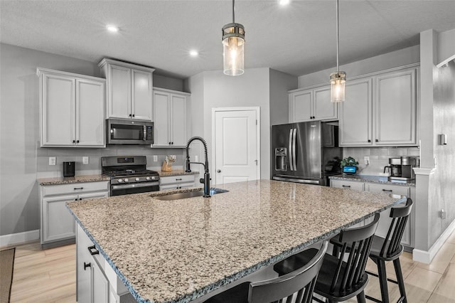 11322 Lake Lucaya Dr, Riverview, FL 33579 - kitchen with stainless steel appliances, a sink, baseboards, a kitchen bar, and recessed lighting