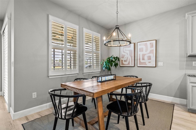 11322 Lake Lucaya Dr, Riverview, FL 33579 - dining area with a chandelier, light wood-style flooring, and baseboards