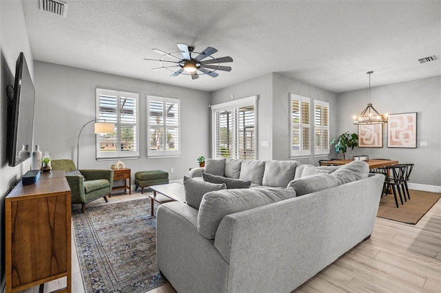 11322 Lake Lucaya Dr, Riverview, FL 33579 - living room with ceiling fan, a chandelier, light wood-type flooring, baseboards, and a textured ceiling
