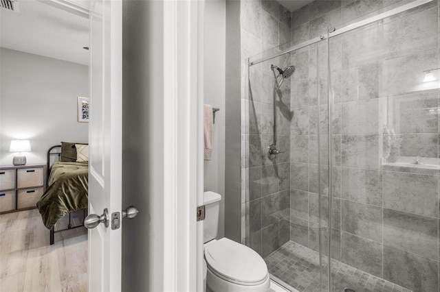 11322 Lake Lucaya Dr, Riverview, FL 33579 - full bath featuring connected bathroom, a shower stall, toilet, and wood finished floors