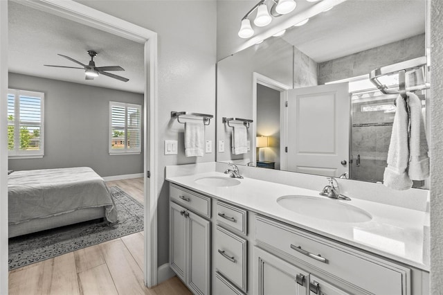 11322 Lake Lucaya Dr, Riverview, FL 33579 - bathroom with ensuite bathroom, double vanity, a ceiling fan, wood finished floors, and a shower stall