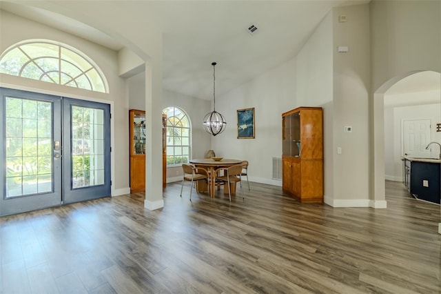 4612 River Overlook Dr, Valrico, FL 33596 - foyer entrance featuring high vaulted ceiling, arched walkways, dark wood finished floors, a chandelier, and french doors