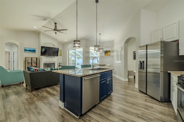 4612 River Overlook Dr, Valrico, FL 33596 - kitchen featuring appliances with stainless steel finishes, arched walkways, blue cabinetry, ceiling fan, and high vaulted ceiling