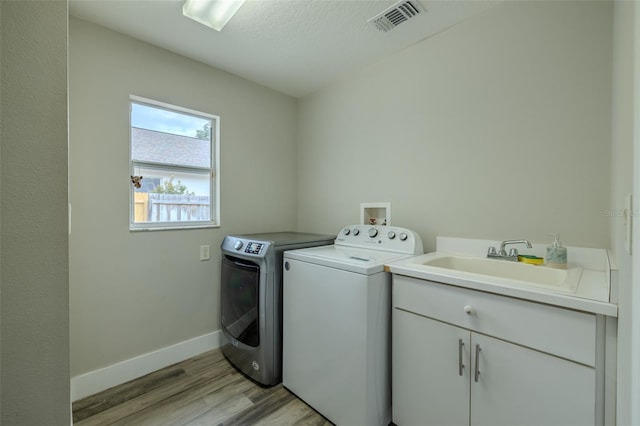 4612 River Overlook Dr, Valrico, FL 33596 - laundry area featuring washer and dryer, light wood-type flooring, and cabinet space