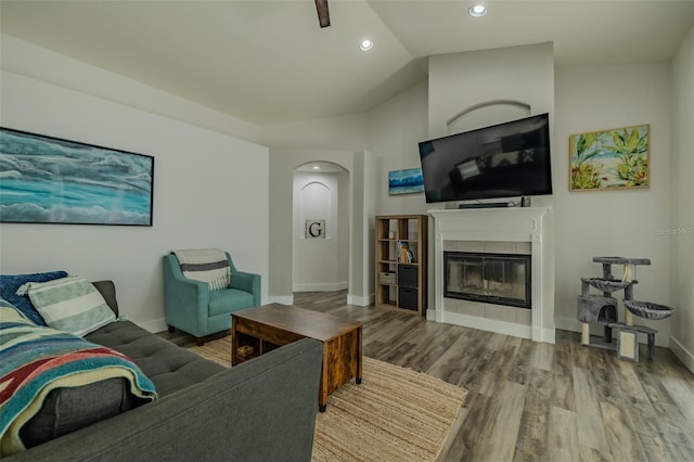 4612 River Overlook Dr, Valrico, FL 33596 - living area featuring wood finished floors, a tiled fireplace, arched walkways, recessed lighting, and vaulted ceiling