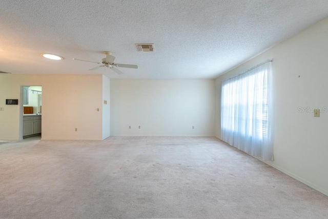 106 Silverbell Ct, Sun City Center, FL 33573 - empty room with ceiling fan, light colored carpet, a textured ceiling, baseboards, and recessed lighting