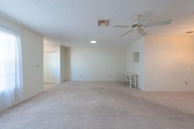 106 Silverbell Ct, Sun City Center, FL 33573 - empty room featuring light colored carpet, a ceiling fan, a textured ceiling, and baseboards