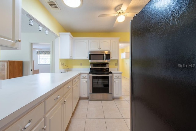 106 Silverbell Ct, Sun City Center, FL 33573 - kitchen with appliances with stainless steel finishes, light countertops, ceiling fan, light tile patterned floors, and white cabinets